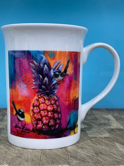 White bone china mug with print of colourful mixed media painting of blue wrens with a pineapple.