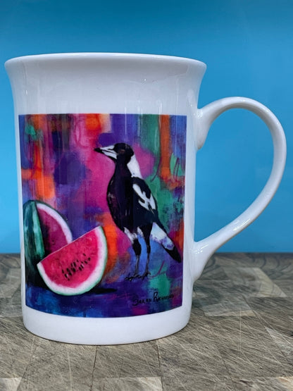 White bone china coffee mug with print of magpie and watermelon on abstract background.