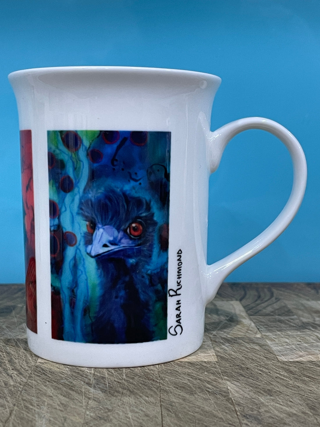 White Bone china mug with prints of colourful mixed media paintings of emus.